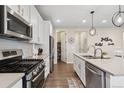 Bright kitchen featuring stainless steel appliances, white cabinetry, a center island, and an adjacent pantry for storage at 16400 Alberta Dr, Parker, CO 80134