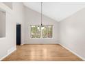 Airy dining room with hardwood floors, natural lighting and a contemporary chandelier at 3205 S Tulare Ct, Denver, CO 80231