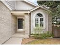 Welcoming front entry with a stylish black door, arched window and neutral brick facade at 3205 S Tulare Ct, Denver, CO 80231