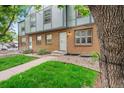 Inviting townhouse with brick exterior, manicured lawn and walkway leading to entrance at 670 Winona Ct # 38, Denver, CO 80204