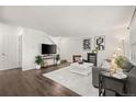 Bright living room with hardwood floors, neutral decor, and open staircase at 670 Winona Ct # 38, Denver, CO 80204