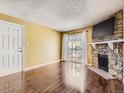Living room with hardwood floors, fireplace, and sliding glass door to balcony at 4400 S Quebec St # M-204, Denver, CO 80237