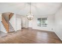 Spacious living room featuring hardwood floors, staircase, decorative light fixture and a large window at 11748 Mill Valley St, Parker, CO 80138