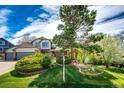 Beautiful home featuring lush landscaping, mature trees, and a well-maintained lawn with a sprinkler system at 6762 Eagle Pl, Highlands Ranch, CO 80130