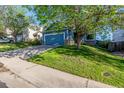View of a charming blue home featuring a two-car garage and well-maintained lawn at 19884 E Villanova Pl, Aurora, CO 80013