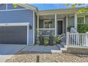Inviting porch featuring gray siding, white railing, and a garage at 537 N 48Th Ave, Brighton, CO 80601