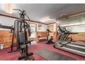 Exercise room with multiple machines, wood-paneled walls, mirrors, and natural light for a motivating workout at 2325 S Linden Ct # 206, Denver, CO 80222