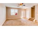 Spacious living room with neutral carpet, natural light, and staircase leading to the next level at 767 Robert St, Longmont, CO 80503
