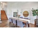 Dining room with hardwood floors, neutral walls, seating for six, and views of a staircase at 15962 E Lehigh Cir, Aurora, CO 80013