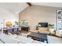 Open concept living space with large couch, TV, hardwood floors, and dining table with seating at 15962 E Lehigh Cir, Aurora, CO 80013