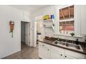 Bright kitchen featuring white cabinets, stainless steel sink, and a window bringing in natural light at 4536 Beach Ct, Denver, CO 80211