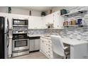 Updated kitchen with stainless steel appliances, quartz countertops, and desk with white cabinets at 650 S Clinton St # 6D, Denver, CO 80247