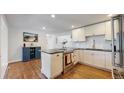 Bright, renovated kitchen features white cabinets, stainless steel appliances, and dark countertops at 6931 W 75Th Pl, Arvada, CO 80003