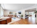 Open-concept living space featuring a stylish bar, wood floors and modern decor at 6931 W 75Th Pl, Arvada, CO 80003
