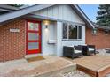 Close up of front entrance with modern red door, cozy porch furniture, and manicured landscaping at 2958 E Euclid Pl, Centennial, CO 80121