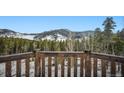 Breathtaking mountain view from the wooden porch, surrounded by a lush forest landscape at 6100 Bear Paw Rd, Golden, CO 80403