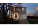 Two-story house with a red door and attached garage at night at 1469 Hummingbird Cir, Brighton, CO 80601