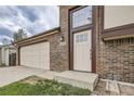 Close up of the front entrance and garage; brick facade and modern front door at 9374 W Friend Dr, Littleton, CO 80128