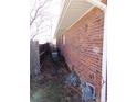 Shows side of a brick home and a partial view of a wooden fence and dry landscaping at 680 Kalmia Way, Broomfield, CO 80020