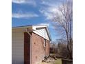 Side view of brick home with dry landscaping and a window on a sunny day at 680 Kalmia Way, Broomfield, CO 80020