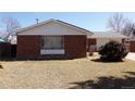 Close up of a charming brick home with bars on the window and dry lawn at 680 Kalmia Way, Broomfield, CO 80020