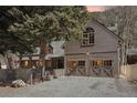 Charming home featuring wood siding, a two-car garage and mature landscaping at 916 Griffith St, Georgetown, CO 80444