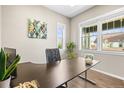 Well-lit office featuring a stylish desk, plants, and bright windows at 7903 E 50Th Dr, Denver, CO 80238