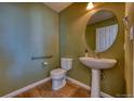This bathroom features a pedestal sink, wood flooring, and a modern design at 7243 S Millbrook Ct # F, Aurora, CO 80016