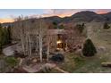 Gorgeous aerial view of home with outdoor deck, patio, outdoor fireplace, and mountain views at 2 Twin Flower, Littleton, CO 80127