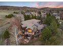 Stunning exterior of the home with a deck overlooking the hillside at dusk at 2 Twin Flower, Littleton, CO 80127