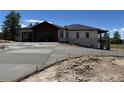 A modern exterior showcasing a wide driveway leading up to a stylish home with stone and wood accents at 1555 Arrowpoint Ct, Franktown, CO 80116