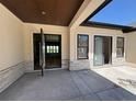 Covered patio featuring stone accents, a coffered wood ceiling, and glass doors providing an indoor/outdoor living space at 1555 Arrowpoint Ct, Franktown, CO 80116