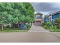 Charming two-story home with stone accents, mature trees, a driveway, and a welcoming porch at 1839 Caleta Trl, Longmont, CO 80504