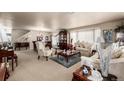 Spacious living room features comfortable seating, elegant décor, and natural light from large windows at 9741 Chambers Dr, Commerce City, CO 80022