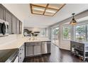 Sunlit kitchen with stainless steel dishwasher, gray cabinets, and a view to outdoor patio space at 4567 Flanders Way, Denver, CO 80249