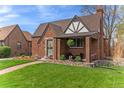 Charming brick home with a well-manicured lawn and a cozy covered porch perfect for relaxing at 2995 Albion St, Denver, CO 80207