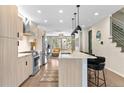 Modern kitchen with stainless steel appliances, island with bar seating, and open layout at 3885 Vrain St, Denver, CO 80212