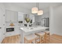 Bright kitchen with quartz countertops, stainless appliances, pendant lighting, and counter seating at 9081 Westminster Blvd, Westminster, CO 80031