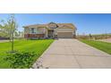 Inviting home boasts a lush green lawn and long concrete driveway leading to a two-car garage at 42073 Colonial Trl, Elizabeth, CO 80107