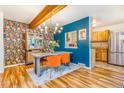 Dining room showcasing a wooden table, vibrant orange chairs, and statement wallpaper at 1152 S Yosemite Way # 29, Denver, CO 80247