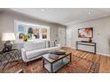 Bright living room with a large bay window, stylish furniture, hardwood floors, and neutral decor at 4745 S Sherman St, Englewood, CO 80113