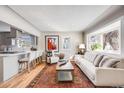 Inviting living area with hardwood floors, a bay window, a sofa, and a view into the updated kitchen at 4745 S Sherman St, Englewood, CO 80113