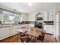 Eat-in kitchen featuring white cabinets, wood floors, and an abundance of natural light at 675 Holland St, Lakewood, CO 80215