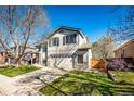 Two-story home with a well-manicured lawn, driveway, and partial tree shadow at 7083 Leopard Dr, Lone Tree, CO 80124