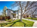Charming two-story home with a well-manicured lawn, tree, and front yard at 7083 Leopard Dr, Lone Tree, CO 80124