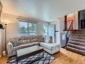 Cozy living room with hardwood floors, a comfortable couch, and a staircase leading to the upper level at 380 S 25Th Ave, Brighton, CO 80601