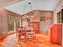 Elegant dining room with wood floors, large windows, and stylish light fixture at 30813 Kings Valley Dr, Conifer, CO 80433