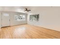 Bright living room featuring gleaming hardwood floors and large windows letting in natural light at 695 S Quitman St, Denver, CO 80219