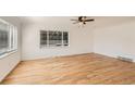 Bright living room featuring gleaming hardwood floors and large windows letting in natural light at 695 S Quitman St, Denver, CO 80219