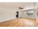 Inviting living room with hardwood floors, white walls, and a ceiling fan, leading to the kitchen at 695 S Quitman St, Denver, CO 80219